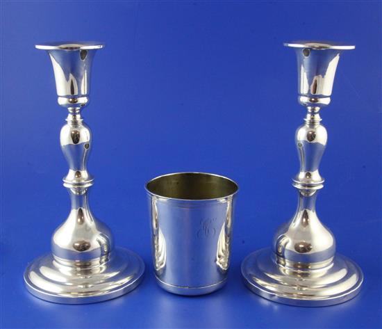 A late 19th/early 20th century French silver beaker and a pair of American sterling silver candlesticks